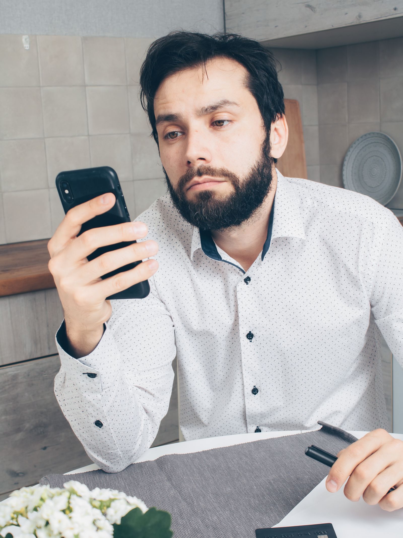 Man checking his phone with a frustrated look