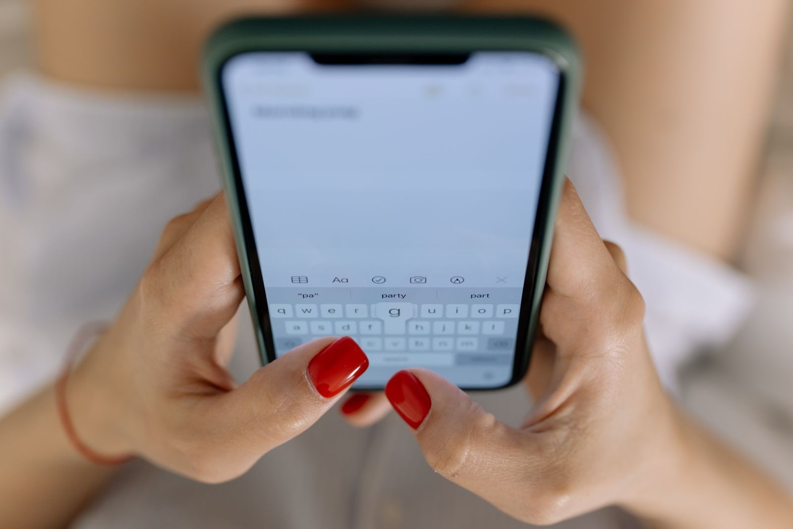 Hands typing on a smartphone touchscreen