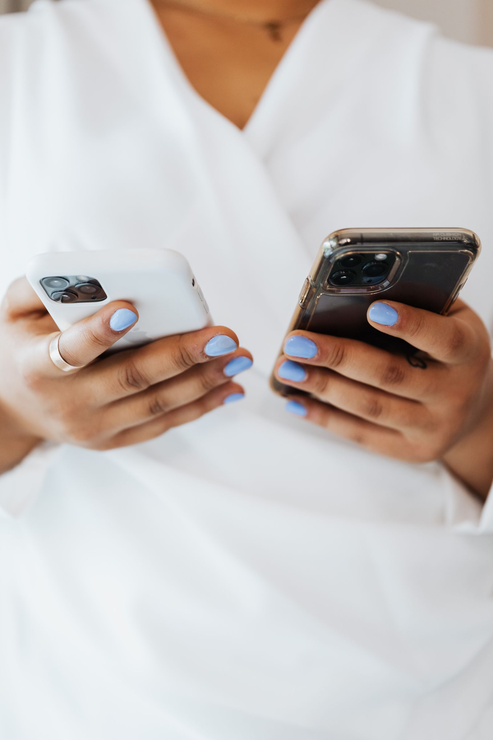 Person holding two smartphones