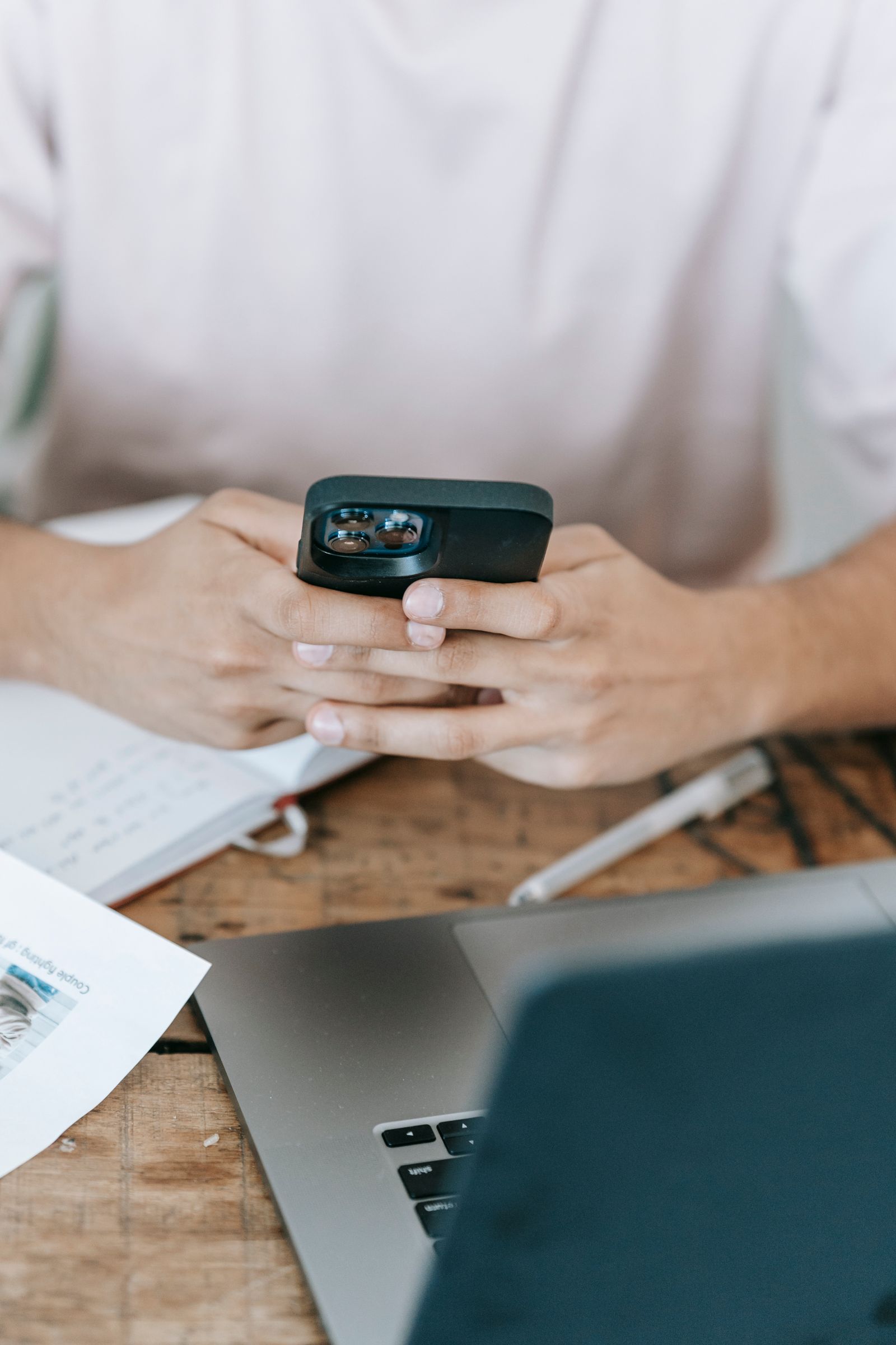 Man using a phone and laptop at a desk